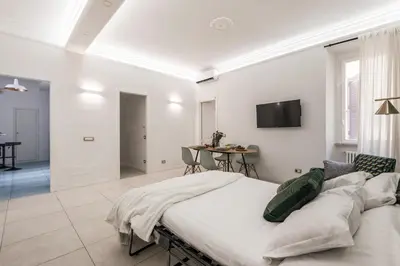 a bedroom with a large bed and a living room at The Best Rent - Bright flat near San Pietro in Rome