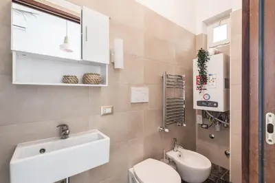 a bathroom with a white sink and a toilet at The Best Rent - Bright flat near San Pietro in Rome