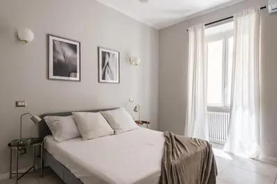a white bedroom with a bed and a window at The Best Rent - Bright flat near San Pietro in Rome