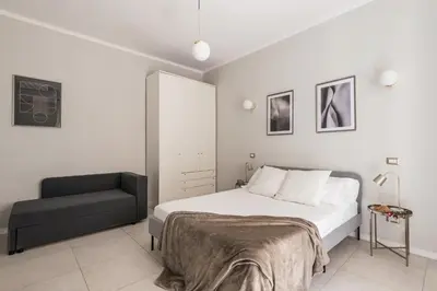 a bedroom with a bed and a chair at The Best Rent - Bright flat near San Pietro in Rome
