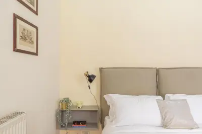 a bedroom with a bed with white sheets and a lamp at iFlat Little & Bright in Trevi in Rome