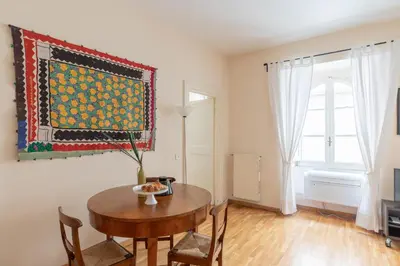 a dining room with a table and a rug on the wall at iFlat Little & Bright in Trevi in Rome