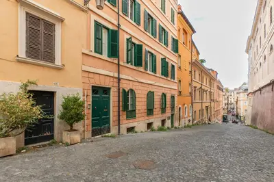 an empty street in a city with buildings with green shutters at iFlat Little & Bright in Trevi in Rome