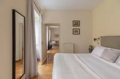 a bedroom with a large white bed and a mirror at iFlat Little & Bright in Trevi in Rome
