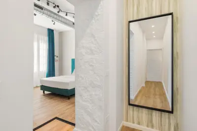 a mirror on a wall next to a bedroom at Adelante rooms Piazza Bologna in Rome