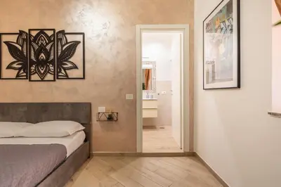 a bedroom with a bed and a door leading to a bathroom at Maison Piazza di Spagna in Rome