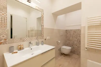 a bathroom with a sink and a toilet and a mirror at Maison Piazza di Spagna in Rome