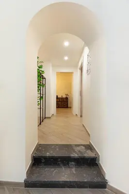 a hallway with a white wall and a black floor at Maison Piazza di Spagna in Rome