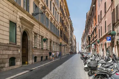 a street with a row of motorcycles parked next to buildings at Maison Piazza di Spagna in Rome