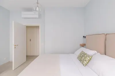 a white bedroom with a bed and a door at iFlat Lovely in Trevi in Rome