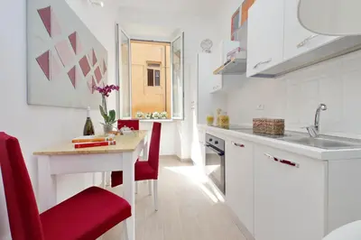 a kitchen with red chairs and a table and a sink at NuvolHouse in Rome
