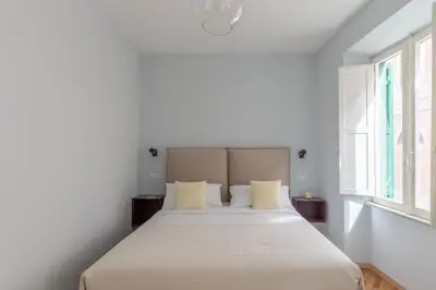 a white bedroom with a large bed with yellow pillows at iFlat Trevi Charming in Rome