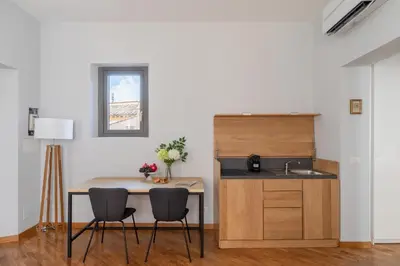 a kitchen with a table and chairs and a sink at iFlat Trevi Charming in Rome