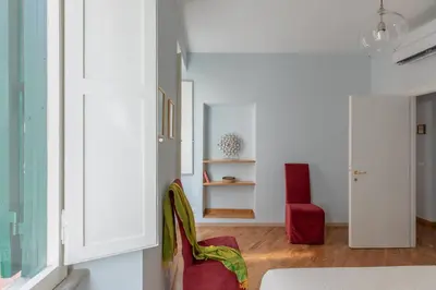 a living room with white walls and red chairs at iFlat Trevi Charming in Rome