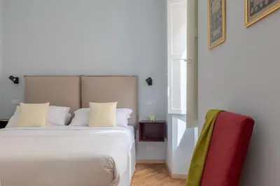 a bedroom with a white bed and a red chair at iFlat Trevi Charming in Rome