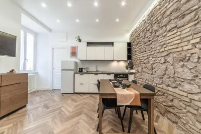 a kitchen with a table and a stone wall at Private apartment in Rome