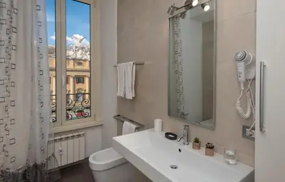a bathroom with a sink and a mirror and a window at Suite Deal in Rome