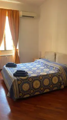a bedroom with a bed with a blue blanket and a window at Nice flat in Furio Camillo in Rome