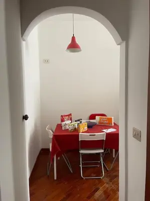 a dining room with a red table and chairs at Nice flat in Furio Camillo in Rome