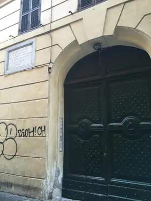 a black door on the side of a building with graffiti at Casa Magiuli' Navona in Rome