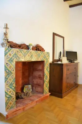 a room with a fireplace with a dresser and a mirror at Casa Magiuli' Navona in Rome