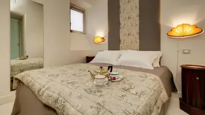 a bedroom with a bed with a tray with two coffee cups at Domus Domitia Luxury Living in Rome