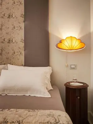 a bedroom with a bed with a yellow umbrella light at Domus Domitia Luxury Living in Rome