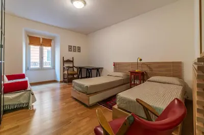 a bedroom with two beds and a chair and a table at GuestHost - Roma Termini Comfy Apartment in Rome