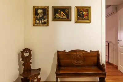 a room with a bench and paintings on a wall at GuestHost - Roma Termini Comfy Apartment in Rome