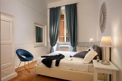 a bedroom with a bed and a blue chair at Daplace - Virginia Apartment in Rome