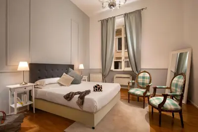 a bedroom with a bed and two chairs at Daplace - Virginia Apartment in Rome