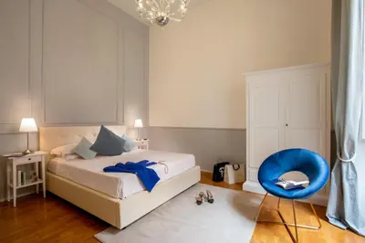 a bedroom with a bed and a blue chair at Daplace - Virginia Apartment in Rome