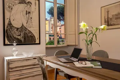 a dining room with a table with a laptop on it at Daplace - Virginia Apartment in Rome
