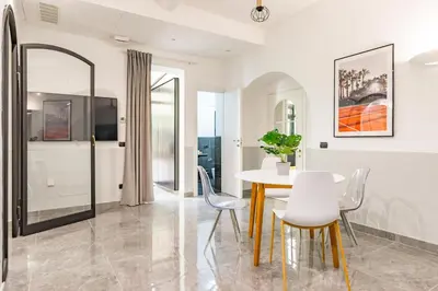 a dining room with a white table and chairs at Laurina deluxe apartment in Rome