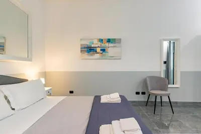 a hotel room with a bed and a chair at Laurina deluxe apartment in Rome