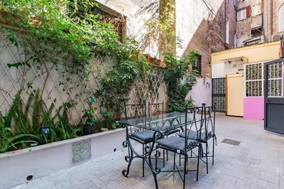 a table and chairs in a courtyard with plants at Laurina deluxe apartment in Rome