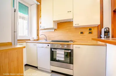 a kitchen with white cabinets and a stove top oven at La Casa di Azzurra in Rome