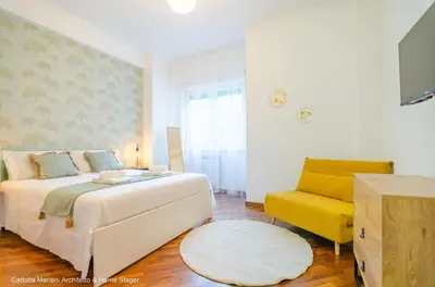 a bedroom with a bed and a yellow chair at La Casa di Azzurra in Rome