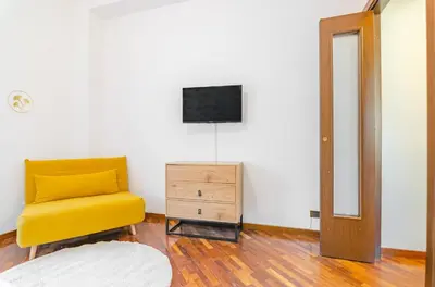 a living room with a yellow chair and a television at La Casa di Azzurra in Rome