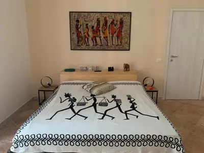 a bedroom with a bed with a painting on the wall at CHEZ NOUS in Rome
