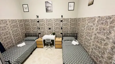 a room with two beds and a table with a desk at Soha's Holiday in Rome