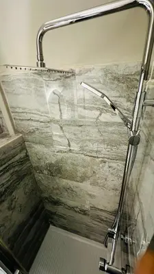 a shower in a bathroom with a stone wall at Soha's Holiday in Rome
