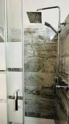 a shower with a glass door in a bathroom at Soha's Holiday in Rome