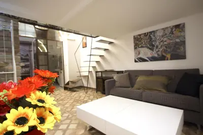 a living room with a couch and flowers at Monti Holiday House in Rome