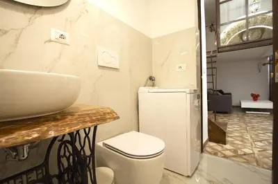 a bathroom with a white toilet and a sink at Monti Holiday House in Rome