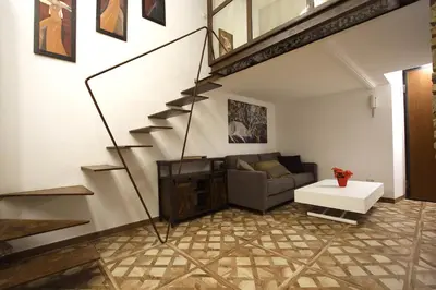 a living room with a staircase and a couch at Monti Holiday House in Rome