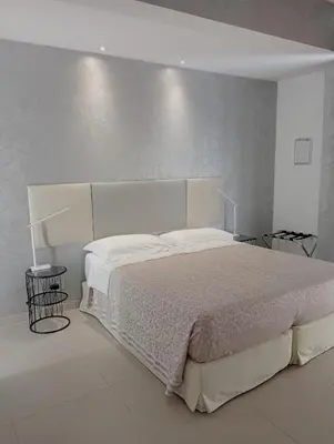 a bedroom with a large bed with white sheets at TEMPORARY HOME ROMA in Rome