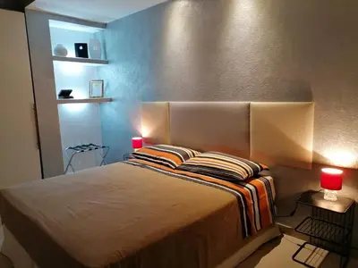 a bedroom with a large bed with two red lamps at TEMPORARY HOME ROMA in Rome
