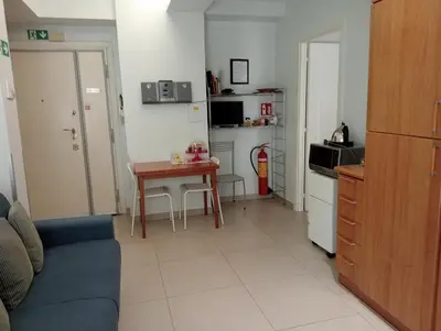 a living room with a table and a kitchen at TEMPORARY HOME ROMA in Rome