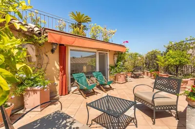 a patio with chairs and tables and a balcony at Casa Colonna, a Burghesius home in Rome